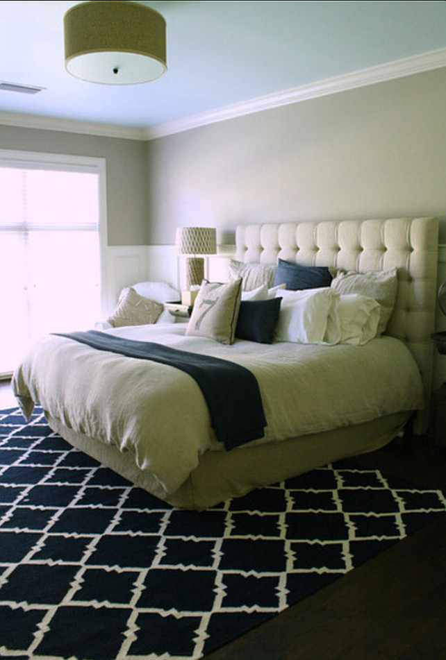 Transitional bedroom with tuffed bed and geometric rug