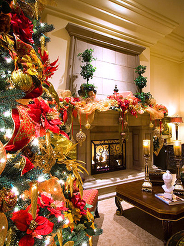 Wide view of holiday decorated livingroom with christmas tree, ribbon draped across the mantel, and ornaments dangling in front of fireplace.